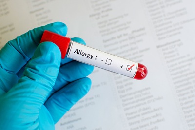 Close up female doctor hands with blood testing tube isolated on gray background